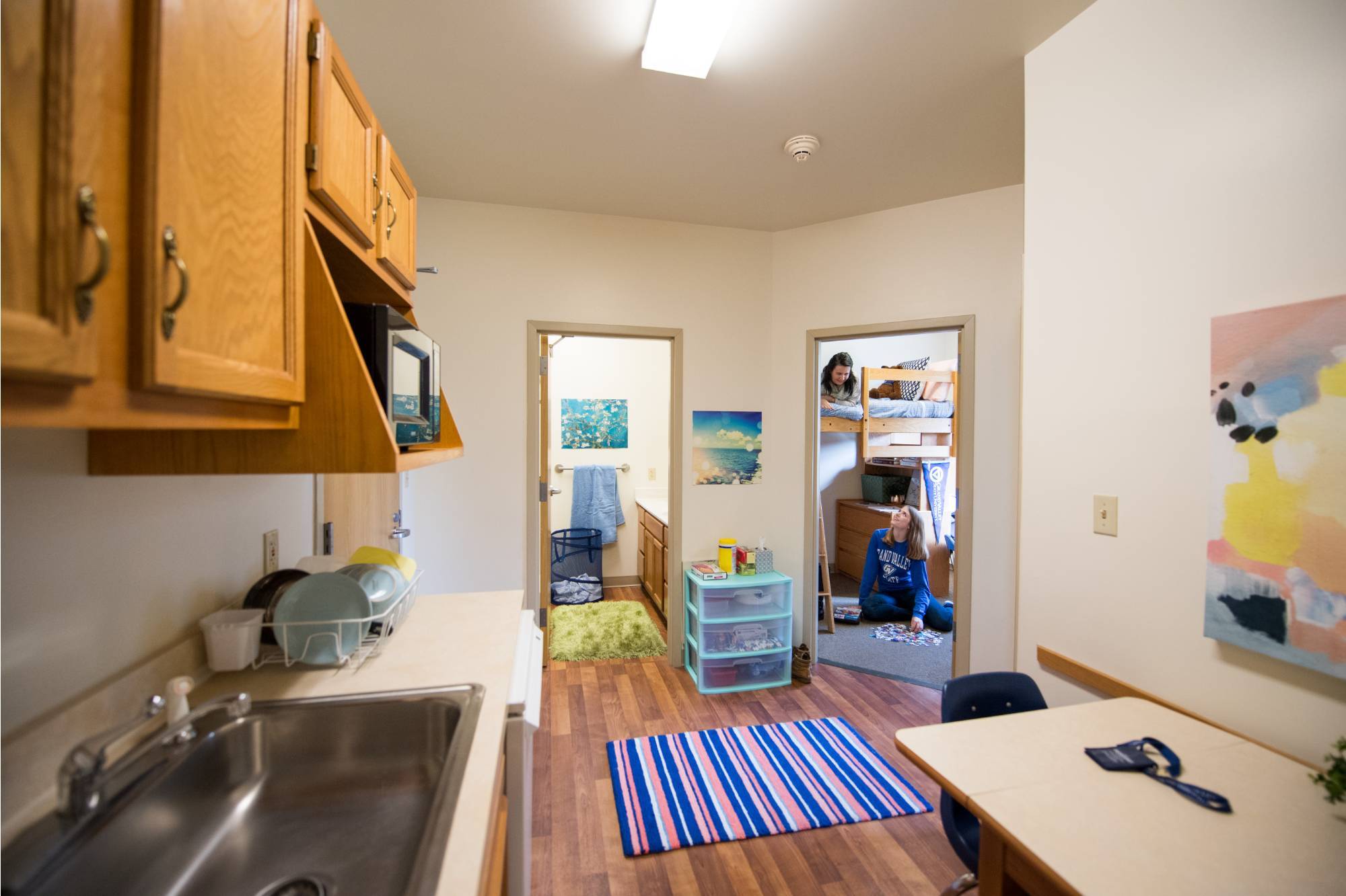 Grand Valley two-bedroom apartment-style roommates talking in the kitchen.